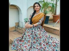 a woman in a long dress is standing on the steps with her arms crossed and smiling