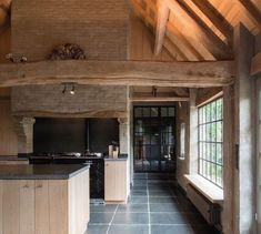 a large kitchen with an island in the center and windows on both sides that look out onto the outdoors