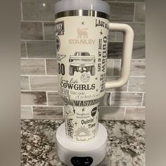 a white coffee cup sitting on top of a counter next to a tile backsplash