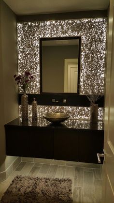 an image of a bathroom with lights on the wall and vanity in front of it