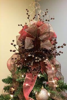 a christmas tree decorated with ornaments and bows