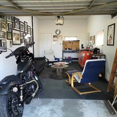 a motorcycle is parked in a garage with pictures on the wall and ladders hanging from the ceiling