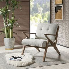 a green chair sitting on top of a rug next to a potted plant