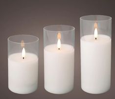 three white candles sitting next to each other