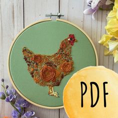 an embroidery pattern with flowers and a chicken on the hoop next to it is shown