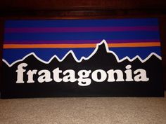 a wooden sign with the word fragonia painted on it's side and mountains in the background