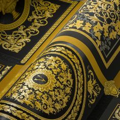 the black and gold wallpaper is very intricately detailed, with golden designs on it