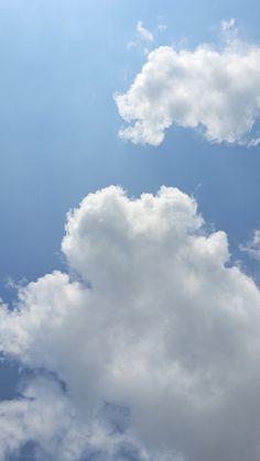 the plane is flying high in the sky with some clouds behind it and an airplane on the far side