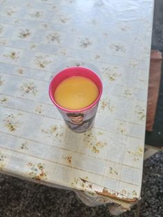 a cup of orange juice sitting on top of a table