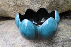 a blue vase sitting on top of a rock