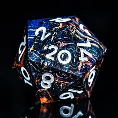 a blue and white dice with numbers on it's sides sitting on a black surface