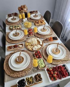 a table set with plates, bowls and trays filled with food on top of it