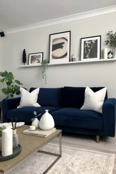 a living room with blue couches and pictures on the wall above them, along with other furniture