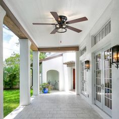 a large white house with a ceiling fan on it's side walk and windows