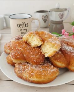 a white plate topped with sugar covered donuts