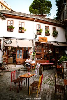 an outdoor cafe with tables and chairs outside