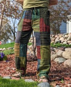 a man standing in the grass with his hands on his hips