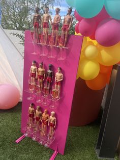 there are many mannequins on display in front of the balloons and streamers