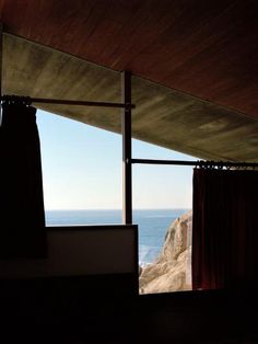 an open window overlooking the ocean with curtains