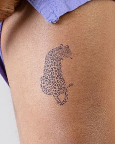 a close up of a person with a tattoo on her leg and the word leopard written in blue ink