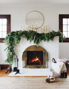 a living room filled with furniture and a fire place covered in greenery next to a fireplace