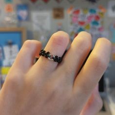 a person wearing a black beaded ring