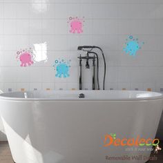 a bath tub sitting in the middle of a bathroom next to a wall with octopus decals on it