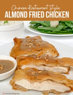 chinese restaurant style almond fried chicken on a white plate with dipping sauce and green salad