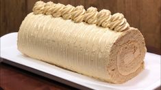 there is a cake made to look like a rolled up roll on a white plate