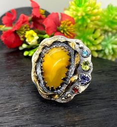 Baltic Amber Gemstone Ring in sterling silver with gold accents size 7 adjustable to bigger size Materials:  Silver 925, 24k Gold plated accents, Baltic Amber, Peridot, Garnet, Ioite, Blue Topaz Face of the ring:  Height - 35mm, Width-35mm, band - 9mm Unique Handcrafted One-of a-kind Design Ring Each Piece of Jewelry in my Collection is Absolutely One of a Kind! When you start wearing a piece of my jewelry you will fall in love with it more and more each day and feel that good Energy and Love th Unique Multi-stone Citrine Rings, Unique Multi-stone Yellow Jewelry, Unique Yellow Multi-stone Jewelry, Unique Yellow Jewelry Ring, Unique Yellow Ring Jewelry, Unique Citrine Rings With Gemstone Accents, Unique Yellow Sterling Silver Rings, Unique Handmade Yellow Rings, Unique Yellow Rings For Anniversary