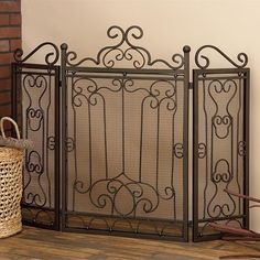 a fireplace screen sitting on top of a wooden floor next to a basket and fire hydrant