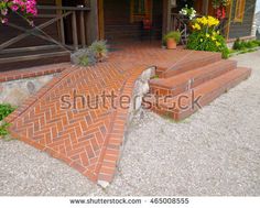 brick steps leading up to the front door of a house with flowers on either side