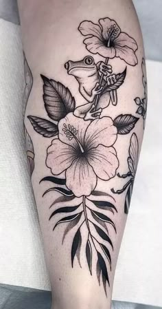 a woman's leg with flowers and leaves on it