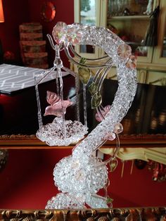 a glass sculpture on top of a table in front of a mirror with birds flying around it