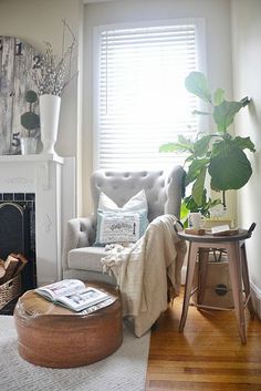 a living room filled with furniture and a fire place next to a white fireplace covered in potted plants