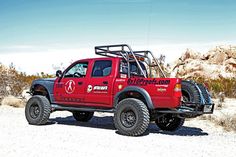 a red pick up truck parked in the desert