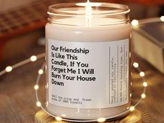 a candle that is sitting on a table with lights around it and the words, our friendship is like this candle if you forget me i will burn your house down