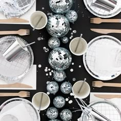 disco balls and silver plates on a black table