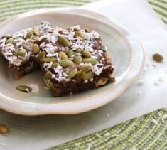 two pieces of dessert sitting on top of a white plate next to a green place mat