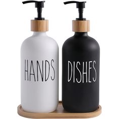 two black and white soap dispensers on a wooden tray