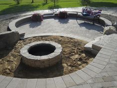 an outdoor fire pit surrounded by brick pavers