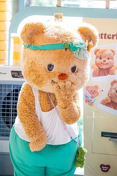 a large teddy bear standing next to a vending machine