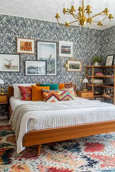 a bed sitting in a bedroom under a chandelier next to a book shelf