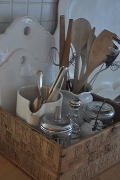 a wooden box with utensils and spoons in it