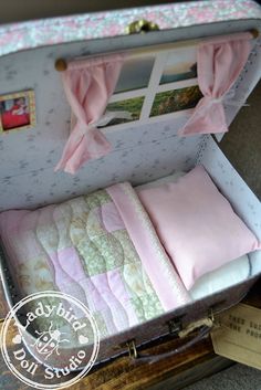 an open suitcase with pink bedding and pillows in it's side opening area