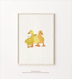 two ducks are standing next to each other on a white surface in front of a framed photograph