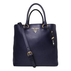 This Prada navy shopping tote is absolutely adorable and is perfect for everyday wear. There is plenty of storage space for your personal belongings. This beautiful navy blue color goes great with most everyday looks and looks stunning with the Prada Paris logo. Includes authenticity cards and Prada dust bag. Model: 1BG865 Navy Blue Leather Gold-tone Hardware Open Closure Detachable/Adjustable Shoulder Strap Strap Drop: 20" inches Double-handle drop: 7" inches Measurements: 14" x 6" x 12" (LWH) Luxury Navy Bags With Gold-tone Hardware, Luxury Navy Shoulder Bag With Gold-tone Hardware, Designer Navy Bags For Daily Use, Luxury Navy Bags With Double Handle, Luxury Navy Bag With Double Handle, Luxury Navy Double Handle Bag, Designer Navy Shopping Bag, Luxury Navy Tote Shoulder Bag, Luxury Navy Shoulder Bag With Top Carry Handle