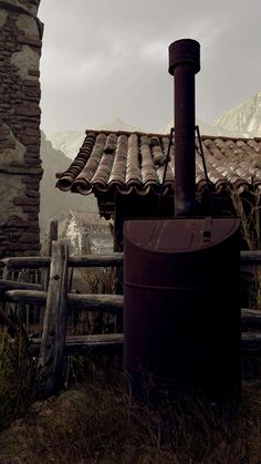 an old brick building with a wood burning stove in the foreground and mountains in the background