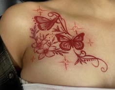 a close up of a woman's chest with flowers and butterflies tattoo on it