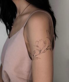 a woman with a flower tattoo on her left arm and right arm behind her head